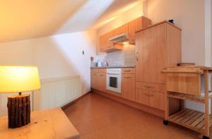 韦斯滕多夫Appartement Paratscher的厨房配有木制橱柜、桌子和台灯。