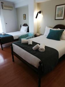 查韦斯Hotel Termas的两张位于酒店客房的床,配有毛巾