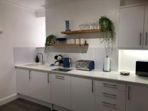 法尔茅斯Bank Place的厨房配有白色橱柜和台面