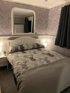 威廉堡Bluebell lodge的卧室配有一张壁挂镜子的床