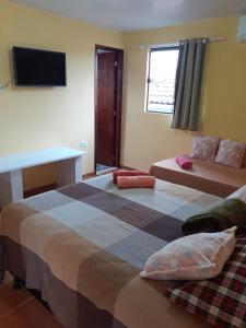 累西腓Recanto Novo Horizonte的一间卧室配有两张床、一张桌子和一台电视。