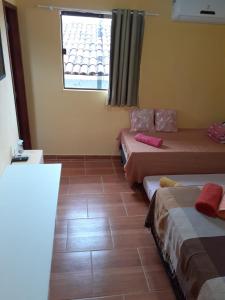 累西腓Recanto Novo Horizonte的客房设有两张床和窗户。