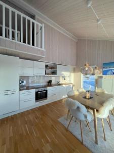 MyroSkarvebo - cabin with amazing view的厨房配有白色橱柜和木桌及椅子