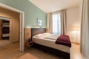 博尔扎诺斯蒂尔格斯卡拉酒店的一间卧室设有一张大床和一个窗户。