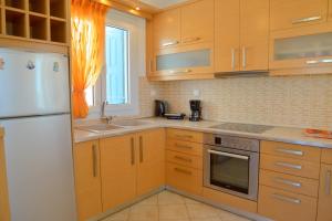特里皮蒂Trypiti Sea View Apartment的厨房配有木制橱柜和白色冰箱。