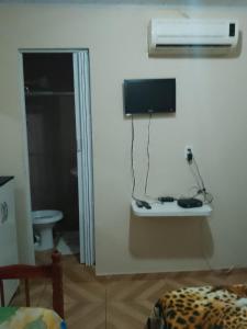 马塞约Hostel Morais的一间墙上配有电视的房间和一张床