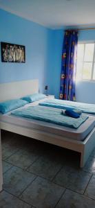蒂哈拉费Finca Marita的卧室内的一张床铺,卧室内有蓝色的墙壁