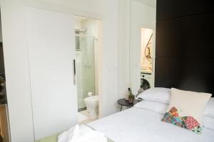 里约热内卢Ipanema 309 Studio的一间带白色床的卧室和一间浴室