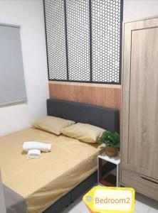 汝来NiDaHomeStay Nilai USIM KLIA WiFi androidtv full aircond的一间卧室配有一张带桌子和植物的床