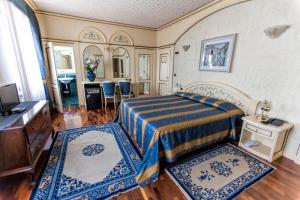 维罗纳克伦巴德欧若酒店的一间卧室配有一张床,房间内有2个地毯