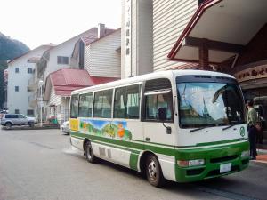 Nosegawa野迫川村酒店的停在大楼前的绿色和白色巴士