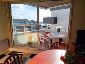 贝诺代Studio with partial sea views in the popular seaside resort of Benodet的客房设有带桌子和窗户的阳台。