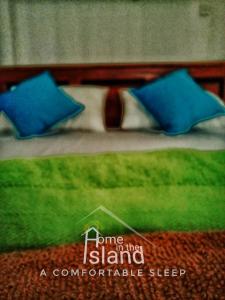坦加拉Home in the Island的一张带两个蓝色枕头的床的画