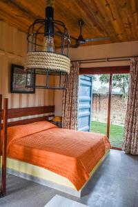 阿格拉Tree of Life Ecotainers Agra的一间卧室配有一张床和一个吊灯