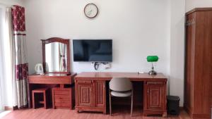 Bồ SơnGALAXY HOTEL Bắc Ninh的一张桌子、一台电视和一张桌子及椅子