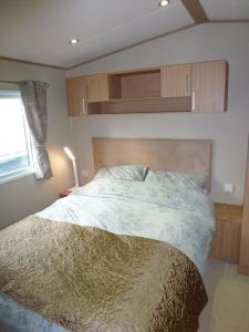 布德Bude Coastal Lodge的一间卧室设有一张床和一个窗口