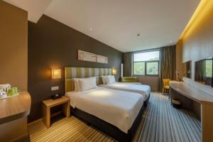 白山长白山万达悦华酒店的酒店客房设有一张大床和一张书桌。