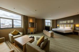 白山长白山万达悦华酒店的大型酒店客房,配有床和沙发