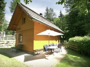 巴德小基希海姆Holiday home in Bad Kleinkirchheim near ski area的一个带桌子和雨伞的小房子