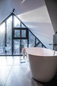 卢布尔雅那Hotel Čad的带窗户的浴室内的白色浴缸