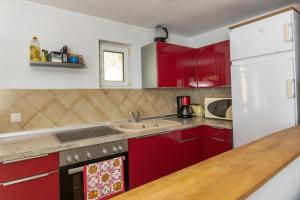文迪施里茨Bungalow am Wassergrundstück的厨房配有红色橱柜和白色冰箱
