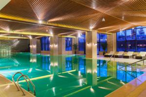白山长白山万达锦华度假酒店的一座带天花板的建筑中的游泳池