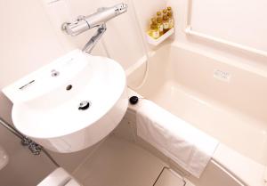 明石市Remington Hotel的白色的浴室设有水槽和浴缸。