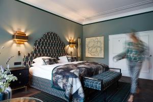 蓬特雷西纳Hotel Walther - Relais & Châteaux的一位女士在一间旅馆房间周围,带一张床