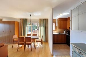 克莱恩 蒙塔纳海尔维蒂亚公寓式酒店的厨房以及带桌椅的用餐室。