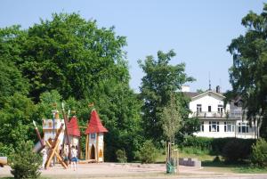 奥胡斯Åhus B&B och Vandrarhem的一群孩子在房子前面的游乐场玩耍