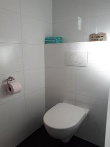 海边的艾格蒙特Zomerhuis Zuid 1的白色的浴室设有卫生间和毛巾。