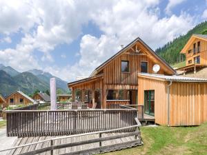 上陶恩Wooden chalet in Hohentauern Styria with sauna的木屋设有甲板,背景为山脉