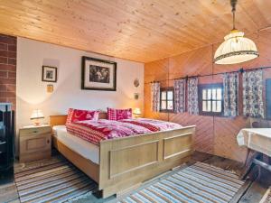 ArriachHoliday home in Arriach near Lake Ossiach的一间卧室配有红色枕头的床