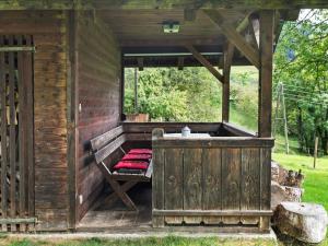 ArriachHoliday home in Arriach near Lake Ossiach的小木屋设有门廊上的长凳