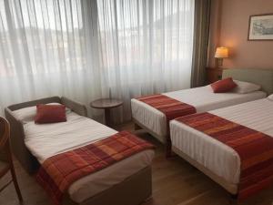 瓦雷泽Crystal Hotel Varese的酒店客房设有两张床和窗户。