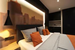 拉廷根JustStay Ratingen的一间卧室配有带橙色和蓝色枕头的床