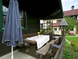 莱奥冈Chalet in Leogang Salzburg with garden的一个带桌子和蓝伞的庭院