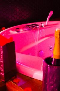 勒布朗-梅尼尔Seasides Paris - Suite Monroe的粉红色的浴缸,上面有粉红色的灯