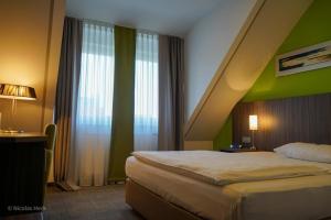 瓦尔多夫阿姆比杨特沃尔德芙酒店的一间卧室设有一张床和绿色的墙壁