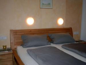奥博沃尔法赫Landeckhof的卧室内的两张床,墙上有两盏灯