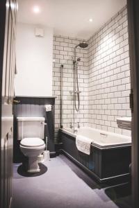 坎伯恩泰亚科斯酒店的带浴缸、卫生间和浴缸的浴室。