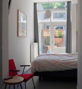 乌得勒支B&B Central Park的一间卧室设有一张床、一个窗口和一把椅子