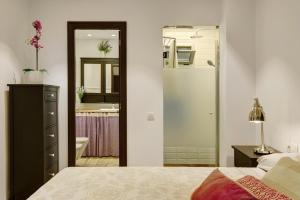 大加那利岛拉斯帕尔马斯Vcv Apartamento San Telmo的一间带一张床的卧室和一间带镜子的浴室