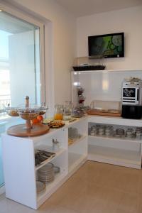 马萨尔福恩Atlantis Lodge的厨房配有白色橱柜,展示食物