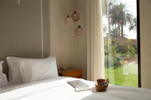 利雅德Aseel Resort的一间卧室配有一张带窗户的床和一台笔记本电脑