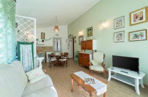 阿尔盖罗Casa Provence Family & Friends Mare & Natura的客厅配有白色沙发和电视
