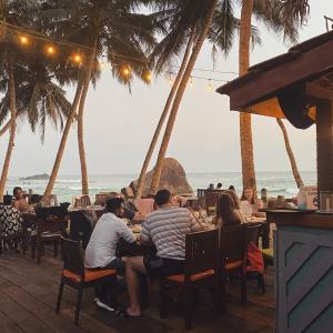 乌纳瓦图纳斯里格姆海滩度假村的一群人坐在海滩上的餐馆里