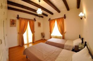Áno KorakiánaVilla Leo Junior的一间卧室设有两张床和两个窗户。