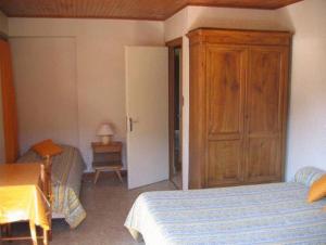 莫尔济讷Chalet Bois Vallons Chambres d'Hôtes的一间卧室配有一张床和一个木制橱柜