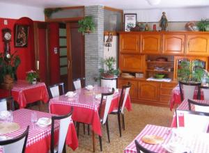莫尔济讷Chalet Bois Vallons Chambres d'Hôtes的一间设有红色和白色桌椅的用餐室